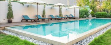 Swimming pool blue sunbed white umbrella in garden at prairie hills resort