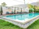 Swimming pool blue sunbed white umbrella in garden at prairie hills resort