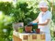 Woman potting oleander at table in garden