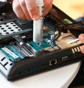 Hand a repairman uses thermal paste syringe apply thermal compound to a CPU. Master replaces thermal