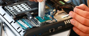 Hand a repairman uses thermal paste syringe apply thermal compound to a CPU. Master replaces thermal
