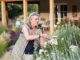 senior grandmother and her 5 year old grandson pruning roses in her garden